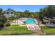 Community pool with a hot tub, lounge chairs, and tables surrounded by beautiful landscaping at 9055 Treasure Trove Ln # 207, Kissimmee, FL 34747