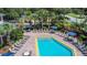 Community pool with chairs and tables and palm trees surrounding it at 9055 Treasure Trove Ln # 207, Kissimmee, FL 34747
