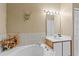 Bathroom soaking tub with tile surround, decorative wall elements and vanity cabinet with sink at 906 Berwick Dr, Davenport, FL 33897
