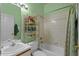 Mint green bathroom featuring a shower over tub combo, vanity, and decor shelving at 906 Berwick Dr, Davenport, FL 33897