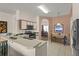 Bright kitchen features white cabinets, a breakfast bar, stainless appliances, and view to a dining area at 906 Berwick Dr, Davenport, FL 33897