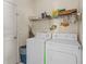 Bright laundry room with washer, dryer, shelving, storage, and door at 906 Berwick Dr, Davenport, FL 33897