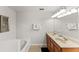 Bathroom with a large soaking tub, double sinks, and bright vanity lighting at 9128 Stromboli Ct, Kissimmee, FL 34747