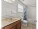 Bright bathroom featuring a vanity, toilet, and tub with a shower curtain at 9128 Stromboli Ct, Kissimmee, FL 34747