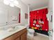 Whimsical bathroom with Mickey Mouse shower curtain, white fixtures, and tile flooring at 9128 Stromboli Ct, Kissimmee, FL 34747