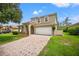 Charming two-story home with a tile roof, paver driveway, and inviting front porch at 9128 Stromboli Ct, Kissimmee, FL 34747