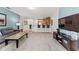 Open-concept living room with bar seating, modern TV and stand, and cozy furniture at 9128 Stromboli Ct, Kissimmee, FL 34747