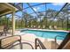 Beautiful pool and spa with a screened enclosure surrounded by greenery at 9128 Stromboli Ct, Kissimmee, FL 34747