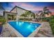 Backyard pool with fountain and poolside seating, surrounded by tropical landscaping at 10836 Royal Cypress Way, Orlando, FL 32836