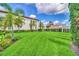 Expansive green backyard surrounded by white fences and tropical palm trees with clear blue skies at 10836 Royal Cypress Way, Orlando, FL 32836