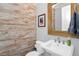 Stylish powder room boasts wood plank accent wall and vanity with framed mirror at 10836 Royal Cypress Way, Orlando, FL 32836