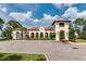Clubhouse exterior featuring a red tile roof, arched walkways, and well-maintained landscaping at 10836 Royal Cypress Way, Orlando, FL 32836