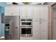 Modern kitchen features stainless steel appliances, oven, microwave and sleek gray cabinetry at 10836 Royal Cypress Way, Orlando, FL 32836