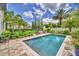 Lush backyard showcasing a pristine pool, manicured lawn, and mature palm trees at 10836 Royal Cypress Way, Orlando, FL 32836