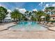 Large pool area with surrounding lounge chairs, palm trees, and a serene waterfront view at 10836 Royal Cypress Way, Orlando, FL 32836