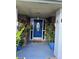 Inviting front porch featuring a blue door flanked by potted plants and sconces at 11922 Ottawa Ave, Orlando, FL 32837