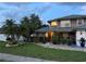Landscaped front yard with palm trees leading to a charming two-story home at 11922 Ottawa Ave, Orlando, FL 32837