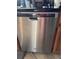 Stainless steel Whirlpool dishwasher in a kitchen with tiled floors and wooden cabinets, seamlessly blending style and utility at 11922 Ottawa Ave, Orlando, FL 32837