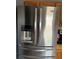 Stainless steel Whirlpool refrigerator with water dispenser and freezer drawer in a kitchen with wooden cabinetry at 11922 Ottawa Ave, Orlando, FL 32837