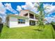 This backyard includes a covered patio, ceiling fans, lush green grass, and a black fence at 13809 Abberwick Dr, Orlando, FL 32832