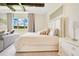 This is an elegant bedroom features tray ceiling detail, a plush bed, and an inviting seating area by the window at 13809 Abberwick Dr, Orlando, FL 32832