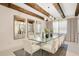 This is a dining room with a modern glass table, chic seating, and decorative mirrors for added elegance at 13809 Abberwick Dr, Orlando, FL 32832
