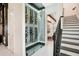 Stylish wine cellar with glass enclosure and modern racking system, adjacent to the staircase at 13809 Abberwick Dr, Orlando, FL 32832