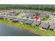 Aerial view of the property featuring a well-manicured lawn and pond-front location at 17795 Blazing Star Cir, Clermont, FL 34714
