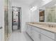 Modern bathroom with double vanity, granite counters, glass shower, and access to walk-in closet at 17795 Blazing Star Cir, Clermont, FL 34714