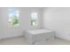 Bedroom with tiled floors, two windows, and a simple bed frame at 17795 Blazing Star Cir, Clermont, FL 34714