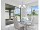 Modern dining room with a glass table, white chairs, and sliding glass doors to the patio at 17795 Blazing Star Cir, Clermont, FL 34714