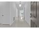 Bright, white foyer with glossy tile, a pendant light, and a view into the dining area at 17795 Blazing Star Cir, Clermont, FL 34714
