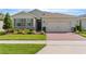 Charming single-story home with a well-manicured lawn, brick driveway, and neutral stucco exterior at 17795 Blazing Star Cir, Clermont, FL 34714