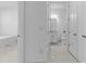 Hallway featuring doorways to the bedroom and a bathroom, with tiled floors and neutral walls at 17795 Blazing Star Cir, Clermont, FL 34714