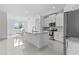 Bright, white kitchen featuring stainless steel appliances and a granite island, adjacent to a dining area at 17795 Blazing Star Cir, Clermont, FL 34714