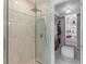 Modern tiled glass shower and doorway to an organized walk-in closet with shelves and ottoman at 17795 Blazing Star Cir, Clermont, FL 34714
