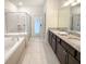 Bright bathroom featuring a double vanity, a soaking tub, and a glass shower at 1876 Summer Dr, Davenport, FL 33897