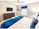 Well-appointed bedroom with modern furnishings, a large window, and blue accents for a comfortable, stylish space at 1876 Summer Dr, Davenport, FL 33897