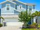 Charming two-story home with a blue exterior, white garage door, brick driveway, and landscaped front yard at 1876 Summer Dr, Davenport, FL 33897