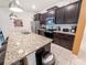 Spacious kitchen showcases dark cabinetry, granite countertops with a breakfast bar, and stainless steel appliances at 1876 Summer Dr, Davenport, FL 33897