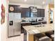 Modern kitchen features stainless steel appliances, dark wood cabinets, and granite countertops with island seating at 1876 Summer Dr, Davenport, FL 33897