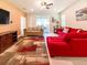 Stylish living room with a red sofa, a flat-screen TV, and sliding glass doors to a patio at 1876 Summer Dr, Davenport, FL 33897