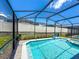 A refreshing screened-in pool with clear blue water and a spacious deck, perfect for outdoor relaxation and entertainment at 1876 Summer Dr, Davenport, FL 33897