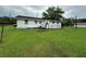 Backyard view of a white house with a spacious green lawn at 1886 Pleasant Hill Rd, Kissimmee, FL 34746