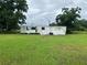 Exterior view of a white mobile home with a green lawn at 1886 Pleasant Hill Rd, Kissimmee, FL 34746