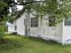 Side view of a white home with visible wear and overgrown foliage at 1886 Pleasant Hill Rd, Kissimmee, FL 34746