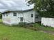 Exterior of property with small stairwell and weathered siding at 1886 Pleasant Hill Rd, Kissimmee, FL 34746