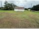 Three-car garage with white doors and a rusty roof on a large grassy lot at 1886 Pleasant Hill Rd, Kissimmee, FL 34746