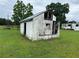 Dilapidated white shed in need of repair on green lawn with damage at 1886 Pleasant Hill Rd, Kissimmee, FL 34746