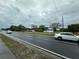 Street view featuring the property and passing cars on a cloudy day, surrounded by mature trees at 1886 Pleasant Hill Rd, Kissimmee, FL 34746